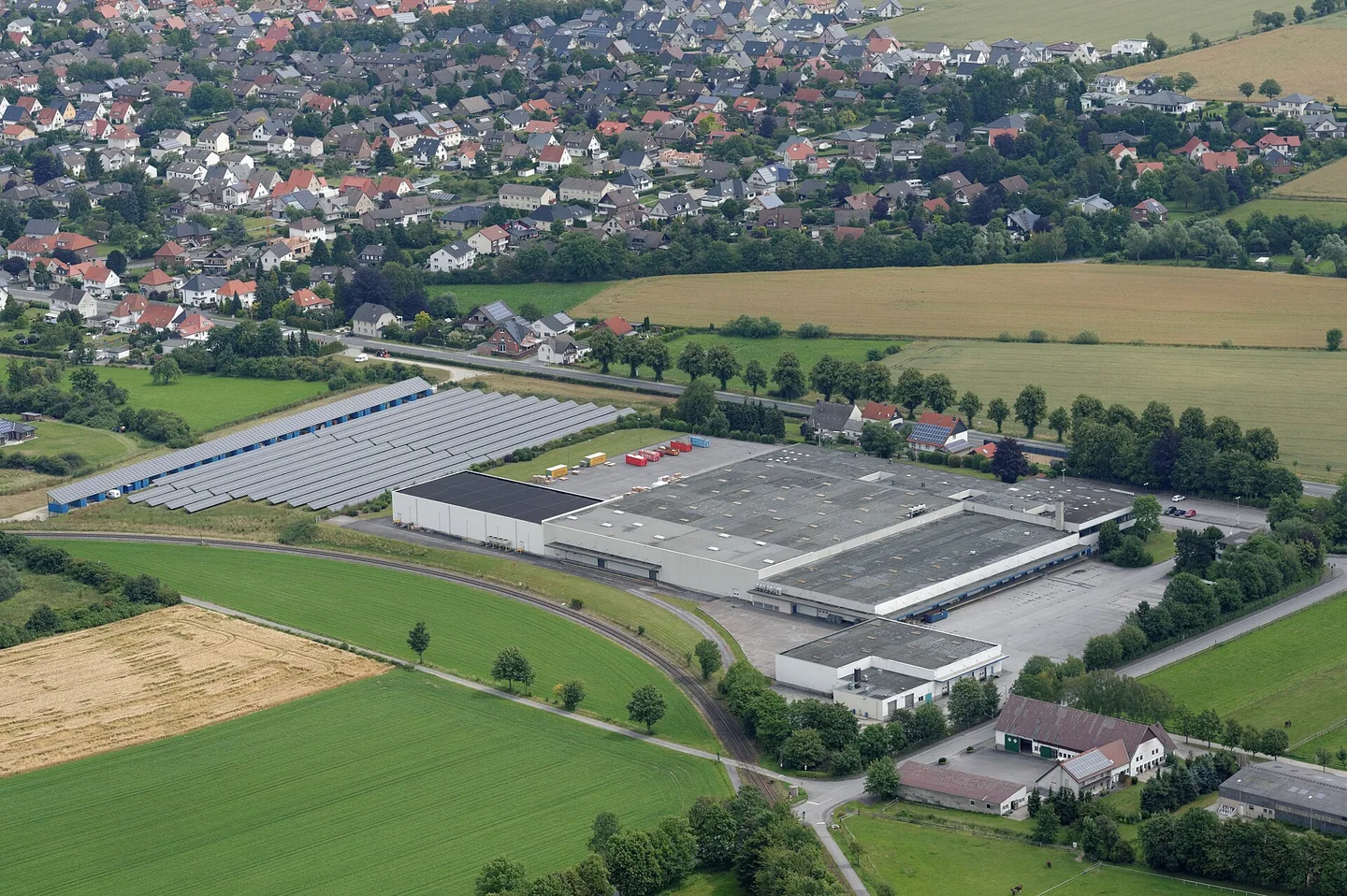 Aerial view of a distribution warehouse beside fields and a town