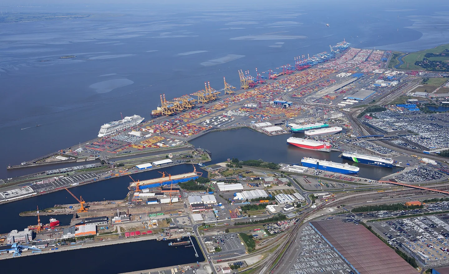 Aerial view of container stacks cranes and quays along a seaport