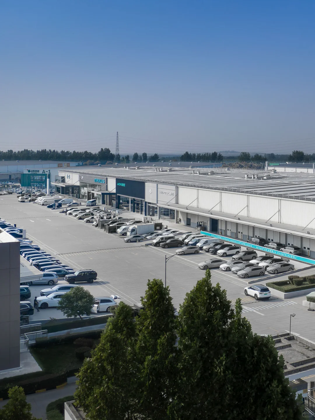 Logistics park loading bays and parked vehicles beneath a blue sky