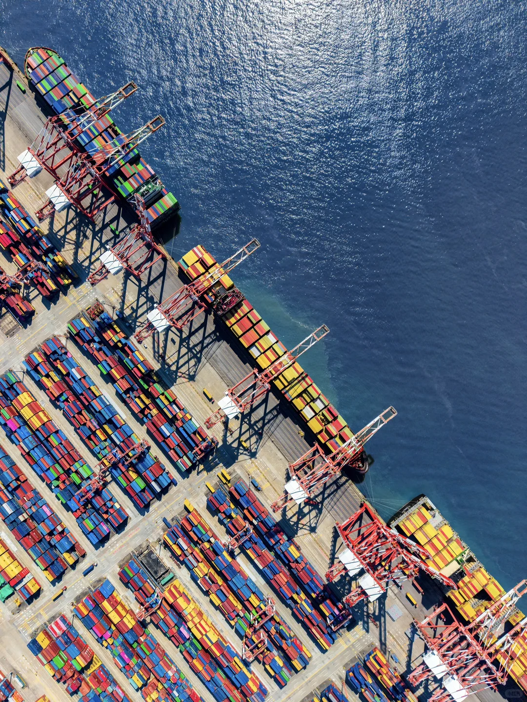 Aerial view of a container terminal beside deep blue harbour water