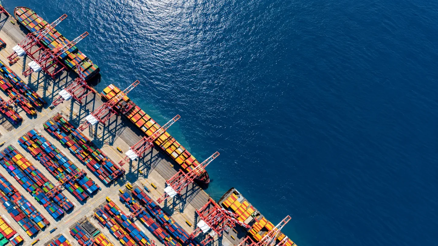Illustrative aerial view of a diagonal container quay beside dark blue water