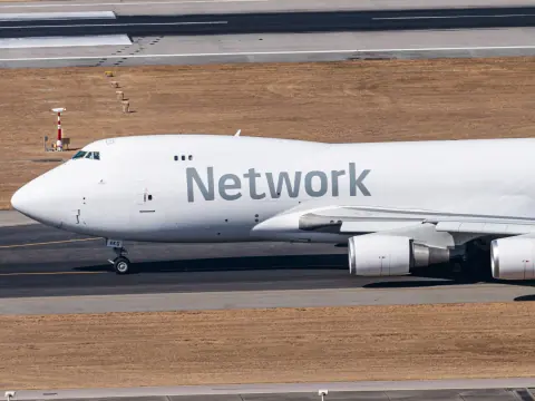 Close side view of a white Network cargo aircraft on the apron