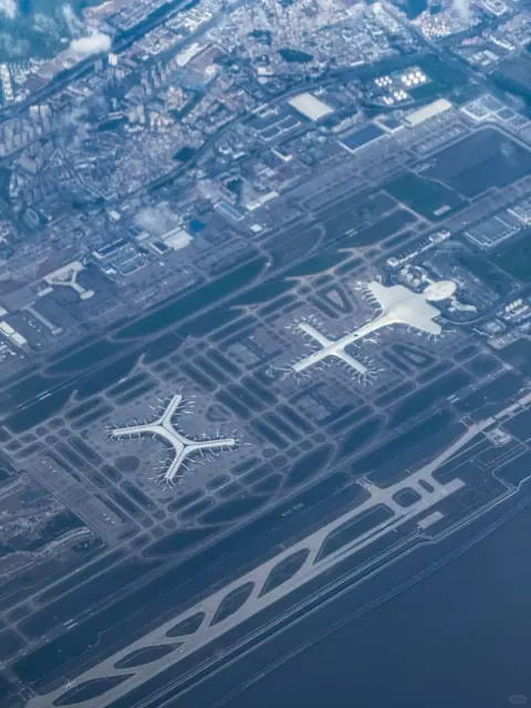 Airport runways and aircraft stands seen through an aircraft window