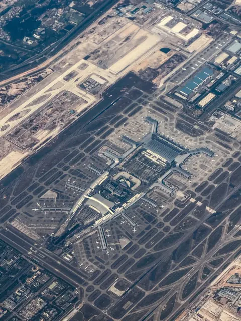 Long runway and airport buildings in a high-altitude aerial view