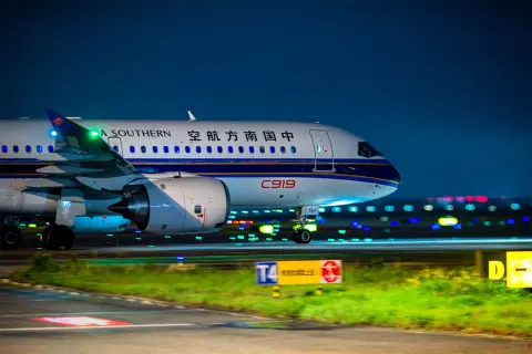 Passenger aircraft beside a marked taxiway under night lighting