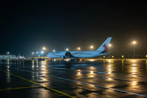 Wide view of aircraft and apron lights reflected on wet tarmac