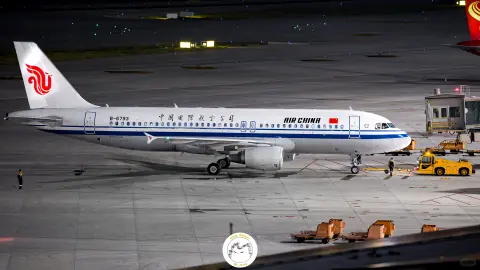 Aircraft being serviced beside yellow ground equipment at night