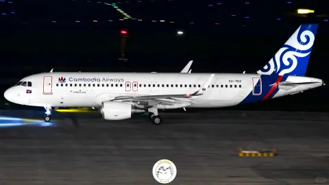 White and blue passenger aircraft and ground vehicles on a night apron