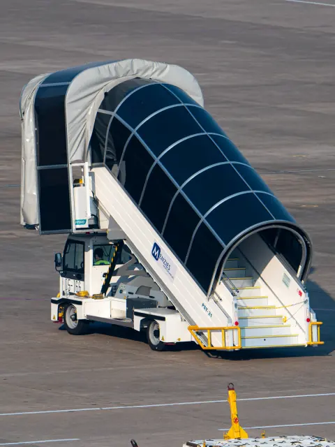 Paired views of covered passenger boarding stairs on an airport apron