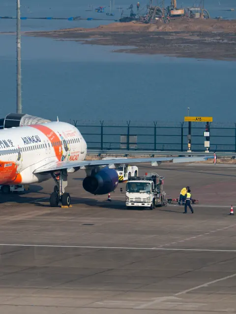 Paired apron photographs of ground service vehicles beside an aircraft