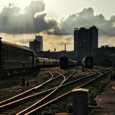Rail freight tracks and a covered loading area beneath a golden evening sky