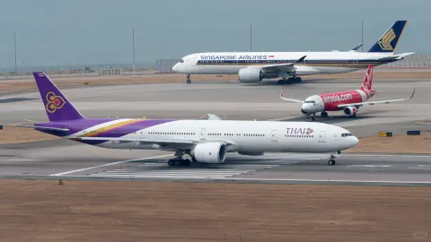 Purple cargo aircraft and other jets across a busy airport apron