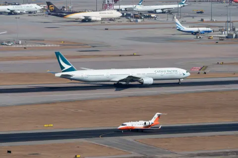 Passenger aircraft crossing parallel taxiways beside the sea