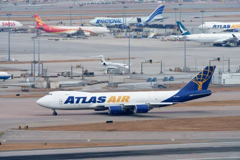 Atlas Air cargo aircraft taxiing past other aircraft near the sea