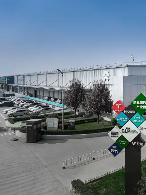 Logistics park frontage with vehicles, trees and warehouse doors