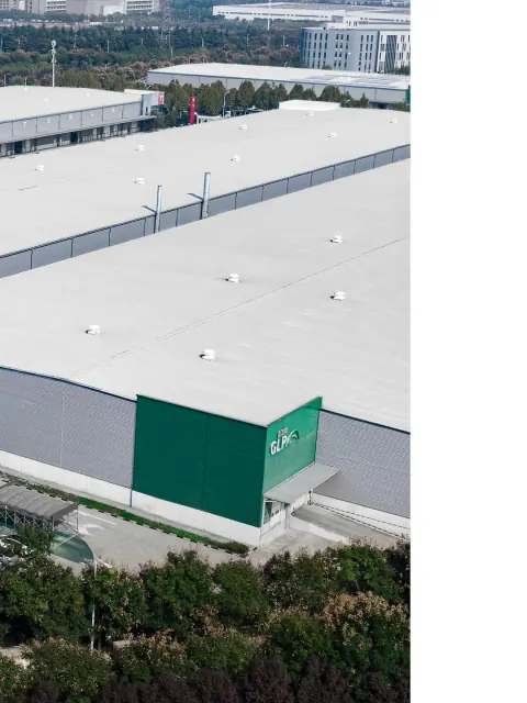 High-angle view of a white warehouse roof and landscaped service yard