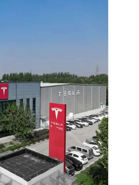 Warehouse corner and vehicle parking beside a red roadside sign