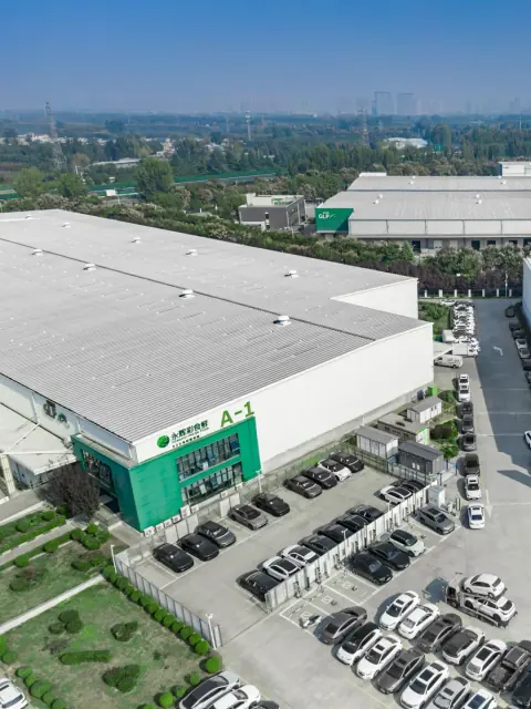 Logistics warehouse entrance, parking rows and surrounding greenery