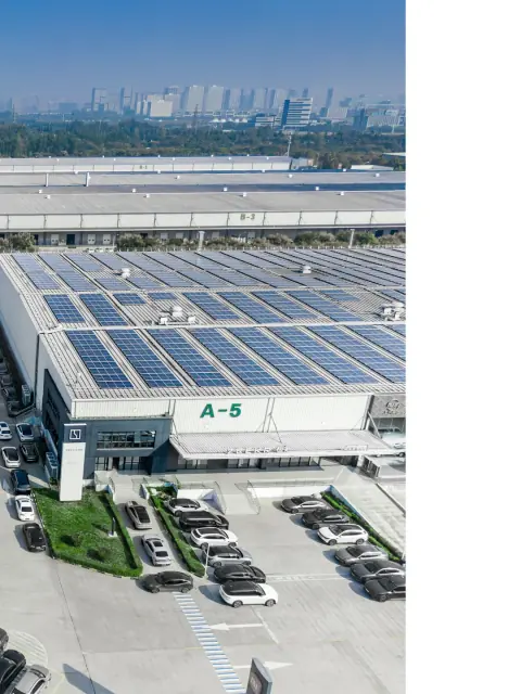 Solar panels across a warehouse roof above a green entrance block