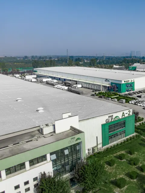 Warehouse rooftops and green entrance facades seen from above