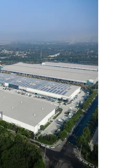 Logistics warehouse roofs and surrounding trees seen from above