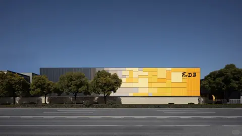 Yellow and grey logistics centre facade behind roadside trees
