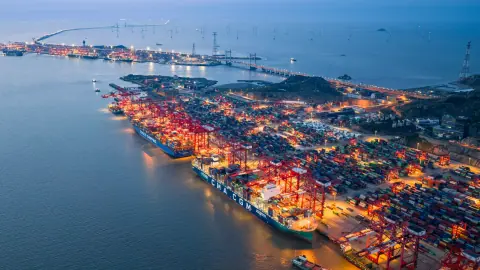 Illuminated container terminal extending into the sea at dusk