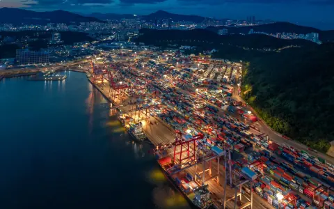 Blue-hour aerial view of a long container quay and surrounding harbour
