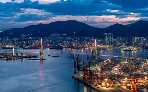 Container terminal and harbour reflections beneath a cloudy evening sky