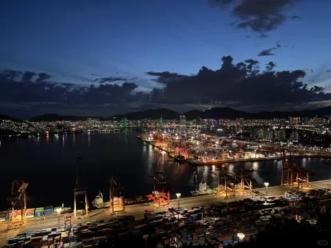 Harbour basin and quay lights beneath a dark, clouded sky