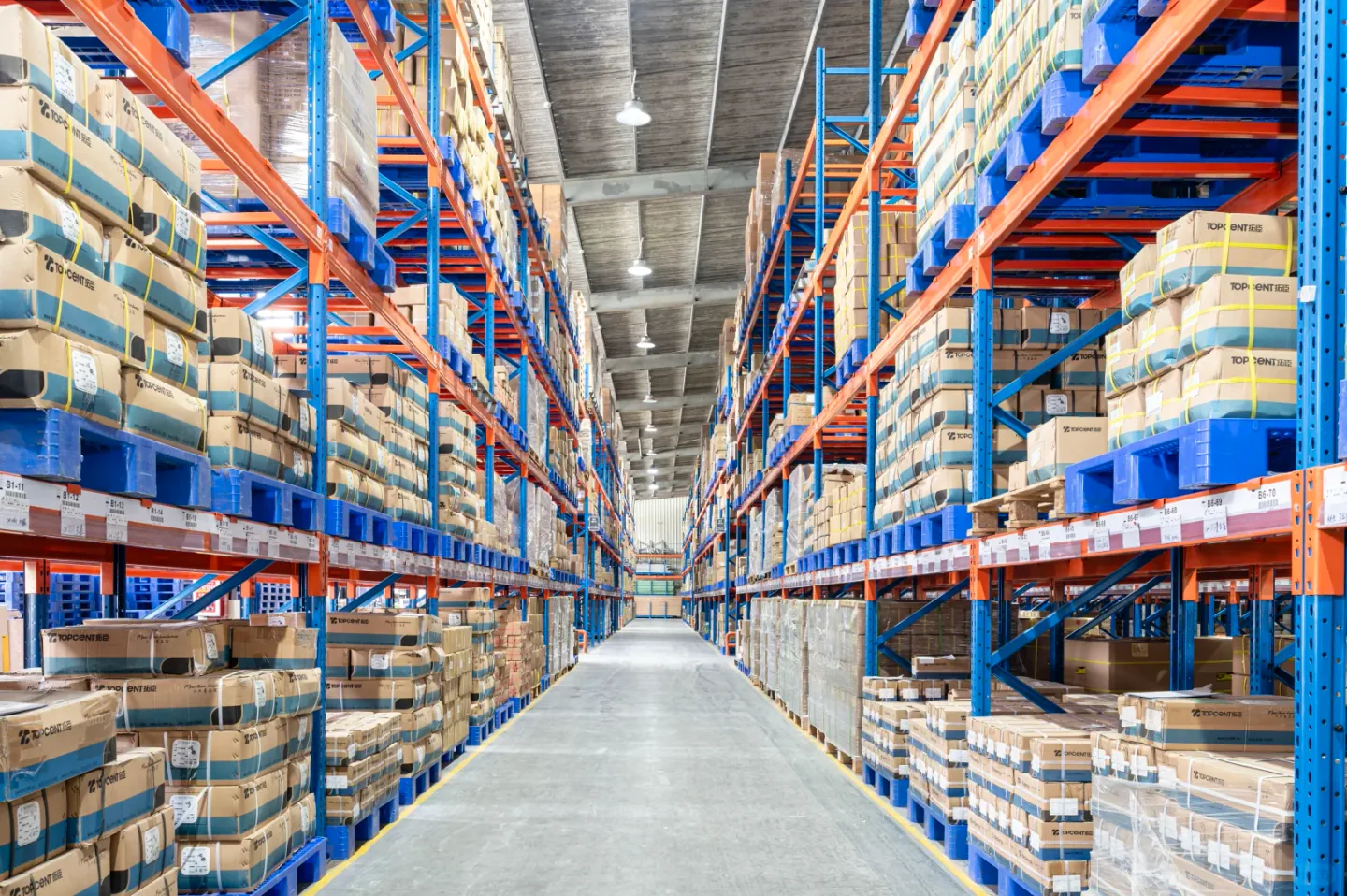 Long warehouse aisle between blue and orange pallet racks