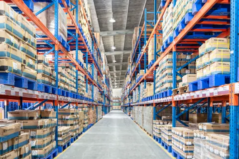 Long warehouse aisle between blue and orange pallet racks