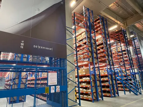 Automated warehouse equipment beside high pallet racks