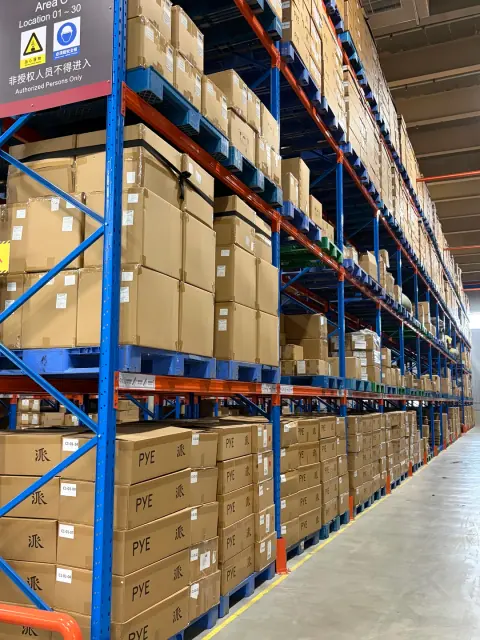 Cartons stored on blue and orange warehouse pallet racks