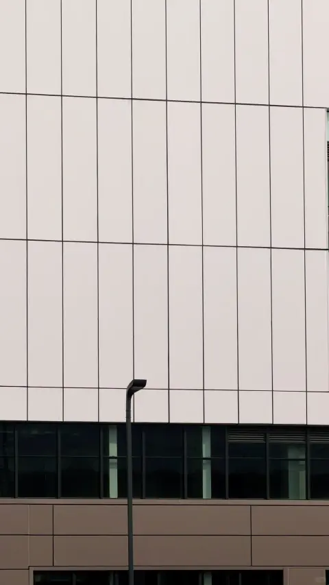 Vertical white facade panels above a warehouse service entrance
