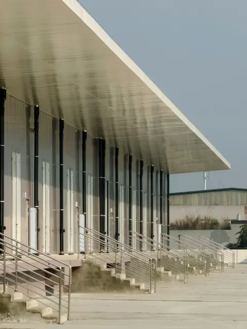 Long sheltered walkway beside a white logistics building