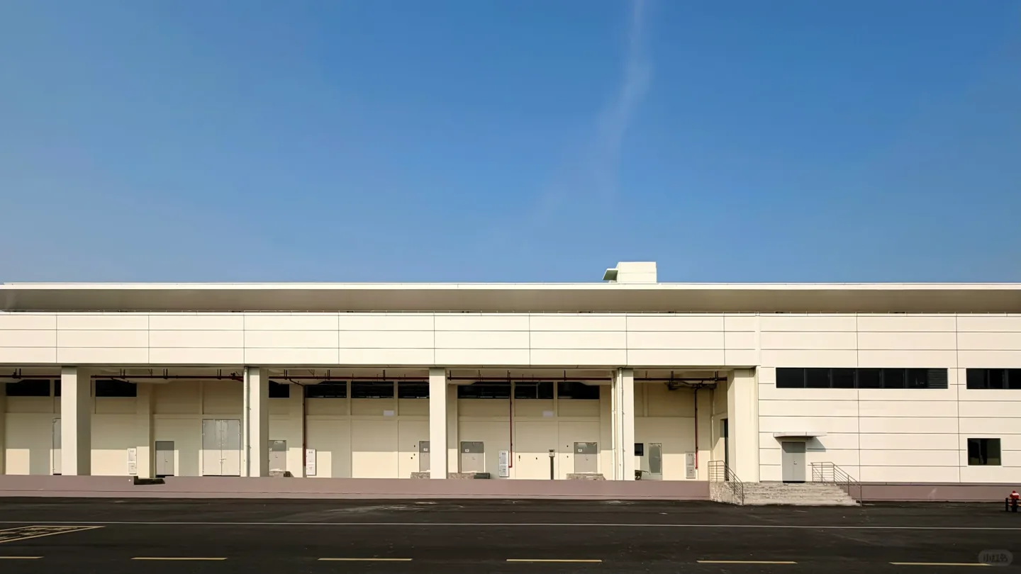 Wide warehouse facade with loading doors under a continuous canopy