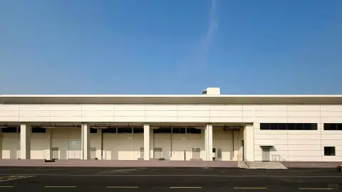 Wide warehouse facade with loading doors under a continuous canopy