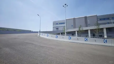 Wide vehicle ramp between modern logistics warehouse buildings