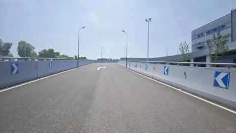 Empty access road leading between warehouse loading structures