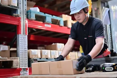 Warehouse worker handling a carton at a packing station