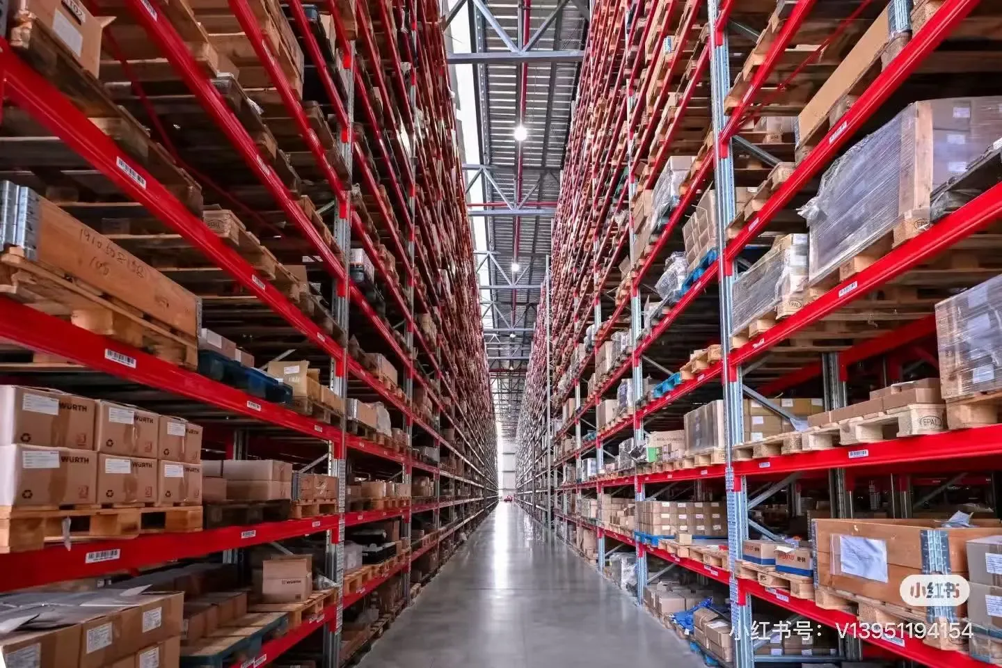 Long red-rack warehouse aisle with densely stored cartons