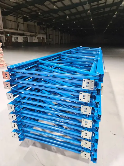 Stacked blue steel components for assembling warehouse shelving